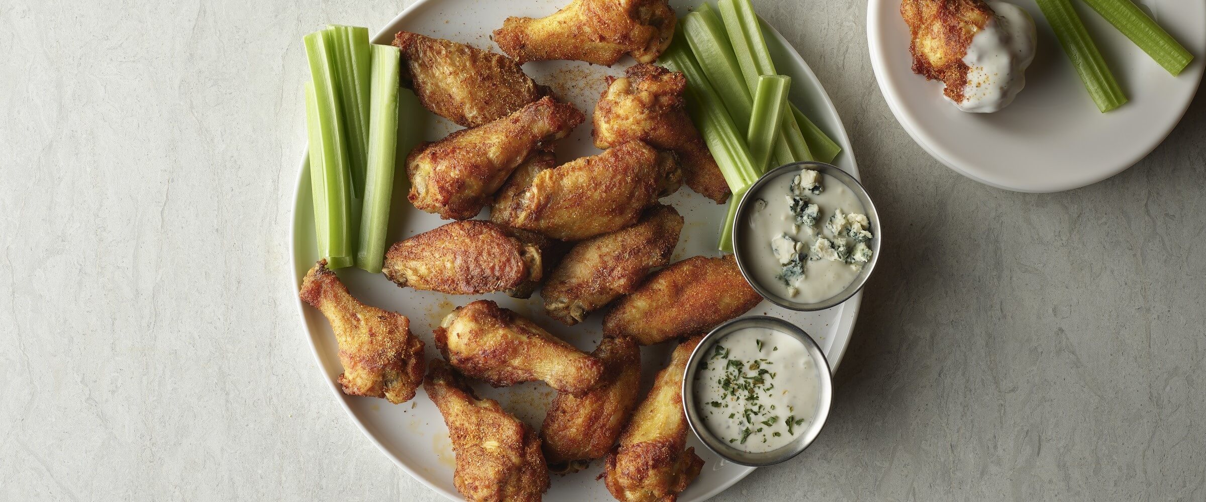 Herb dry rub chicken wings on plate with celery and bleu cheese dip