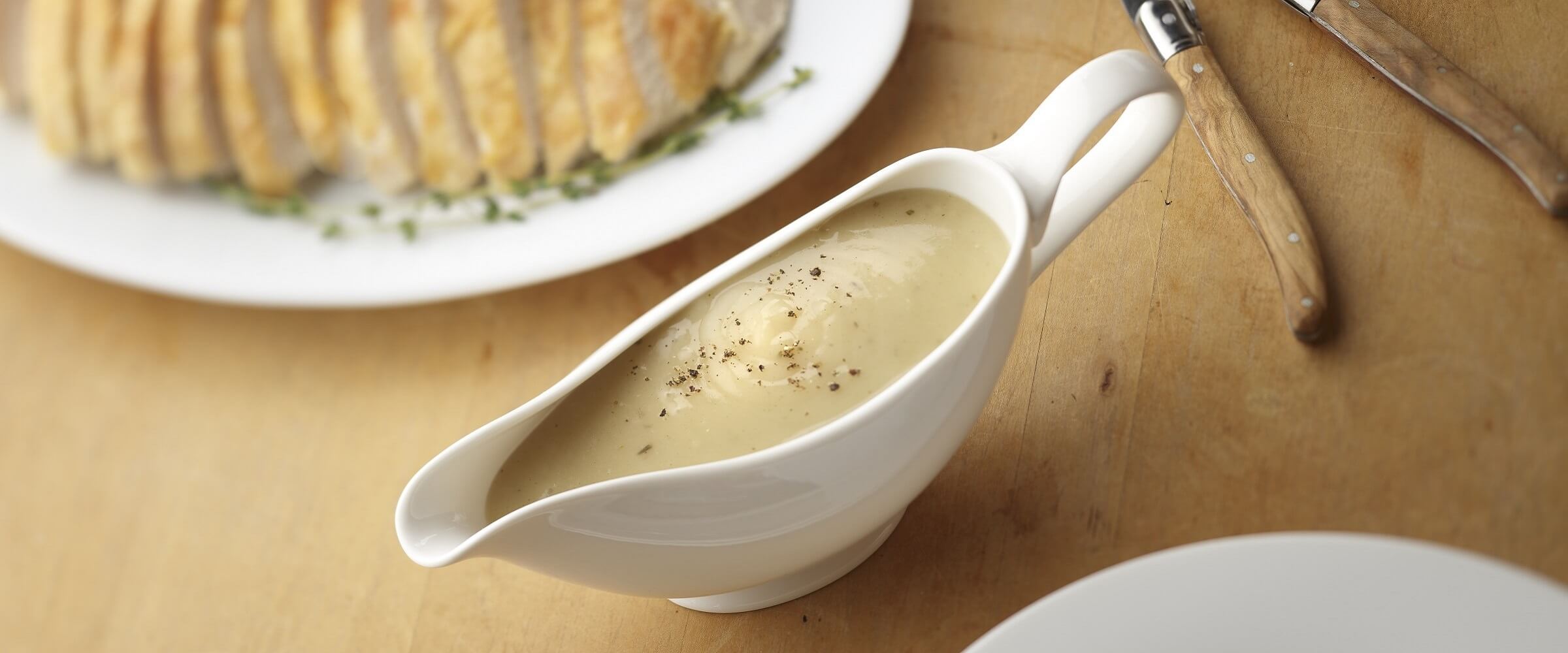 Herb gravy in white serving bowl