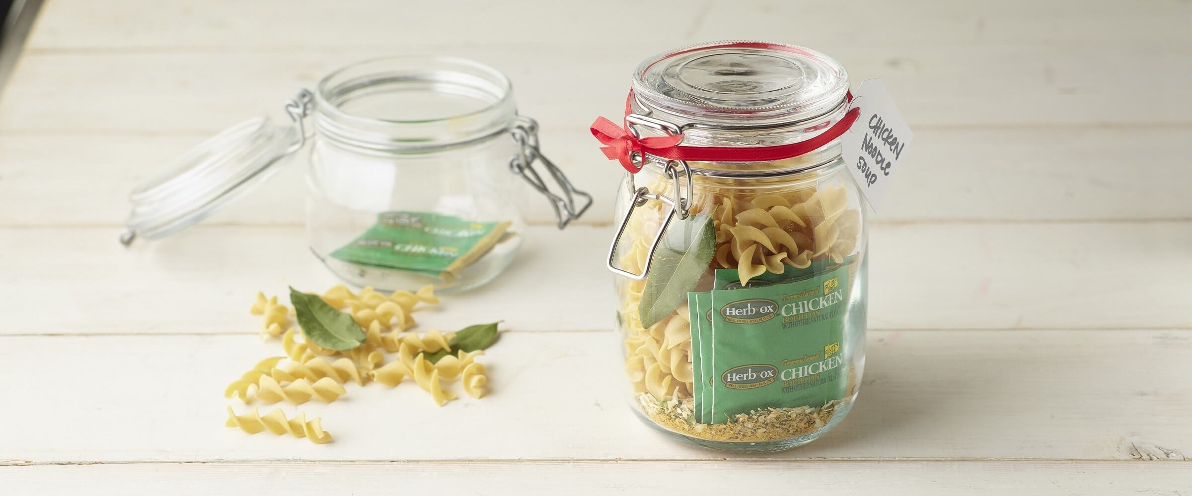 Clear jar with Herb ox packet, spices and dry noodles to make soup