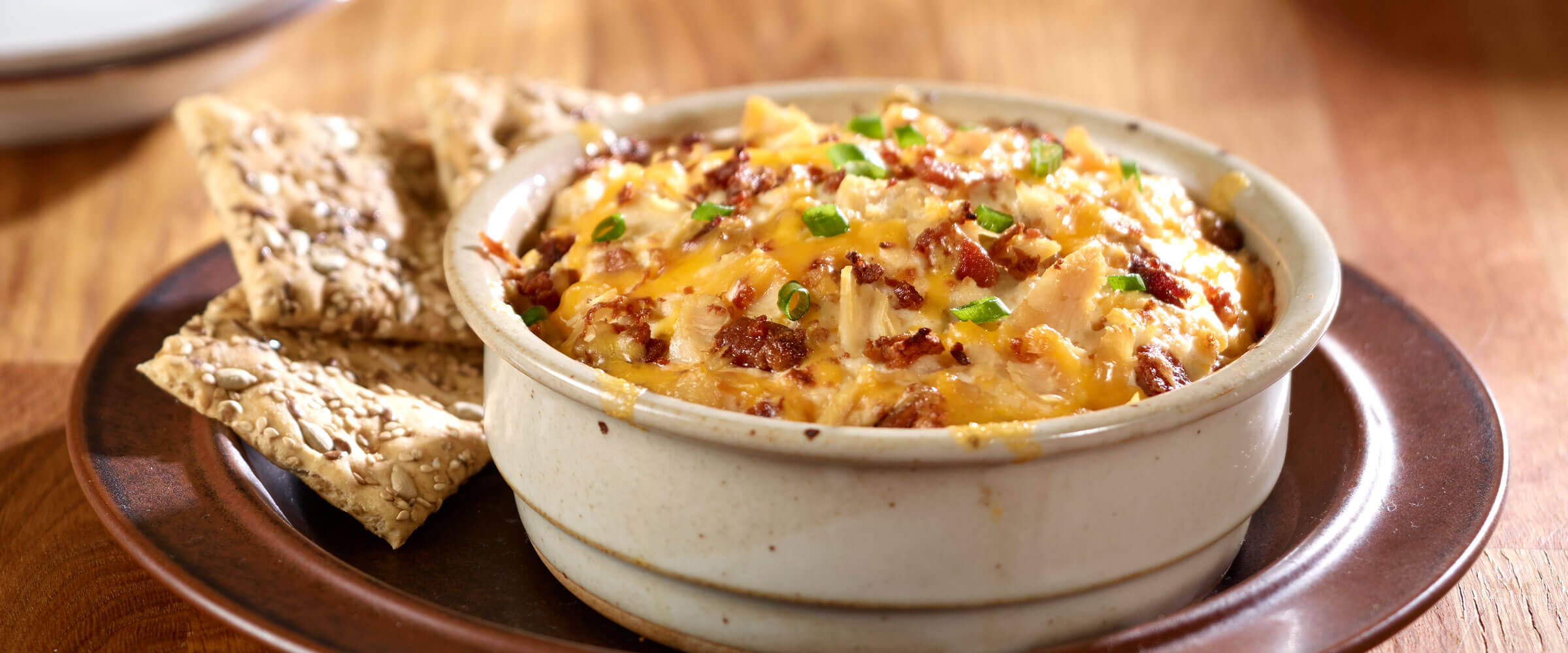 Cheesy-Chicken and Bacon Ranch Dip in bowl with crackers for dipping