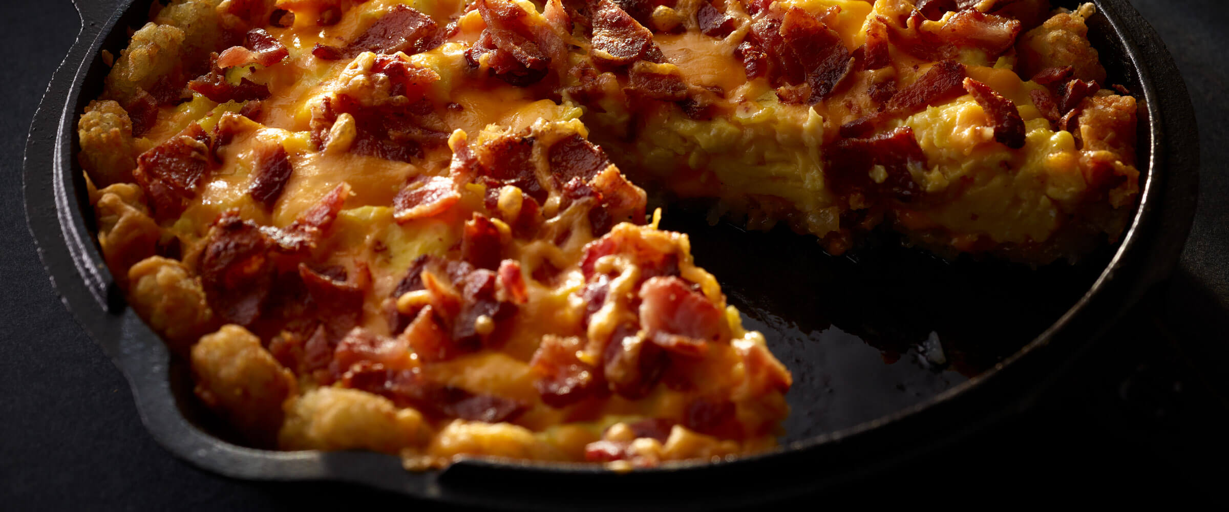 Bacon Potato Puffs Breakfast Pizza in cast iron skillet