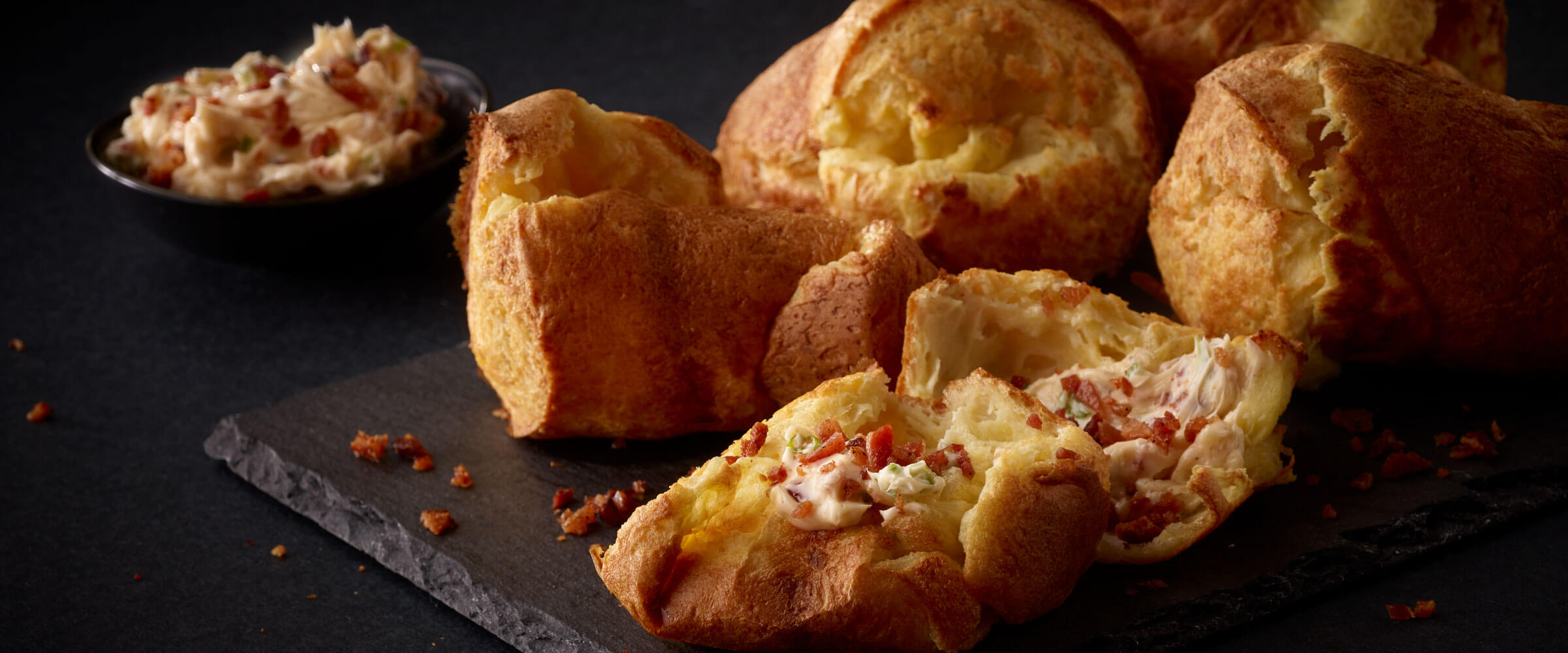 Bacon Chive Butter popovers on black platter