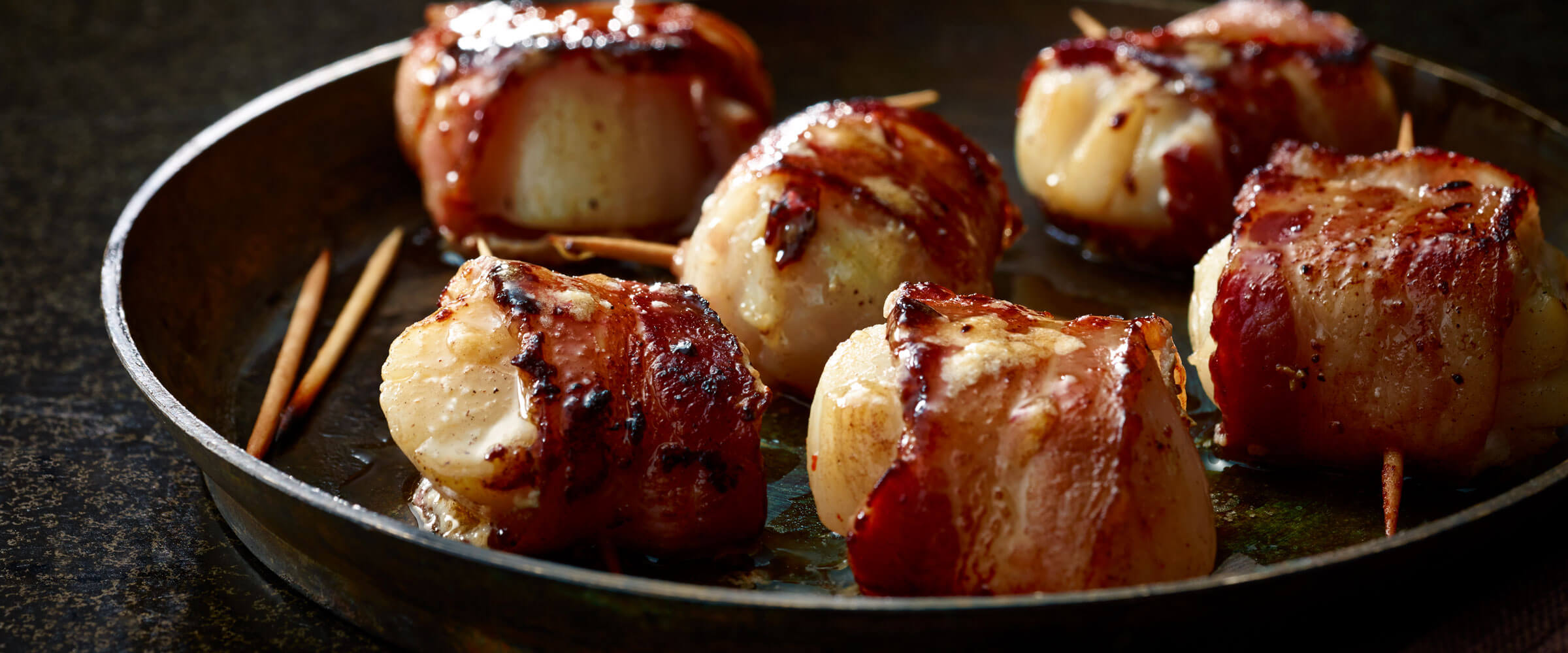 Bacon Wrapped Scallops with toothpicks in serving dish