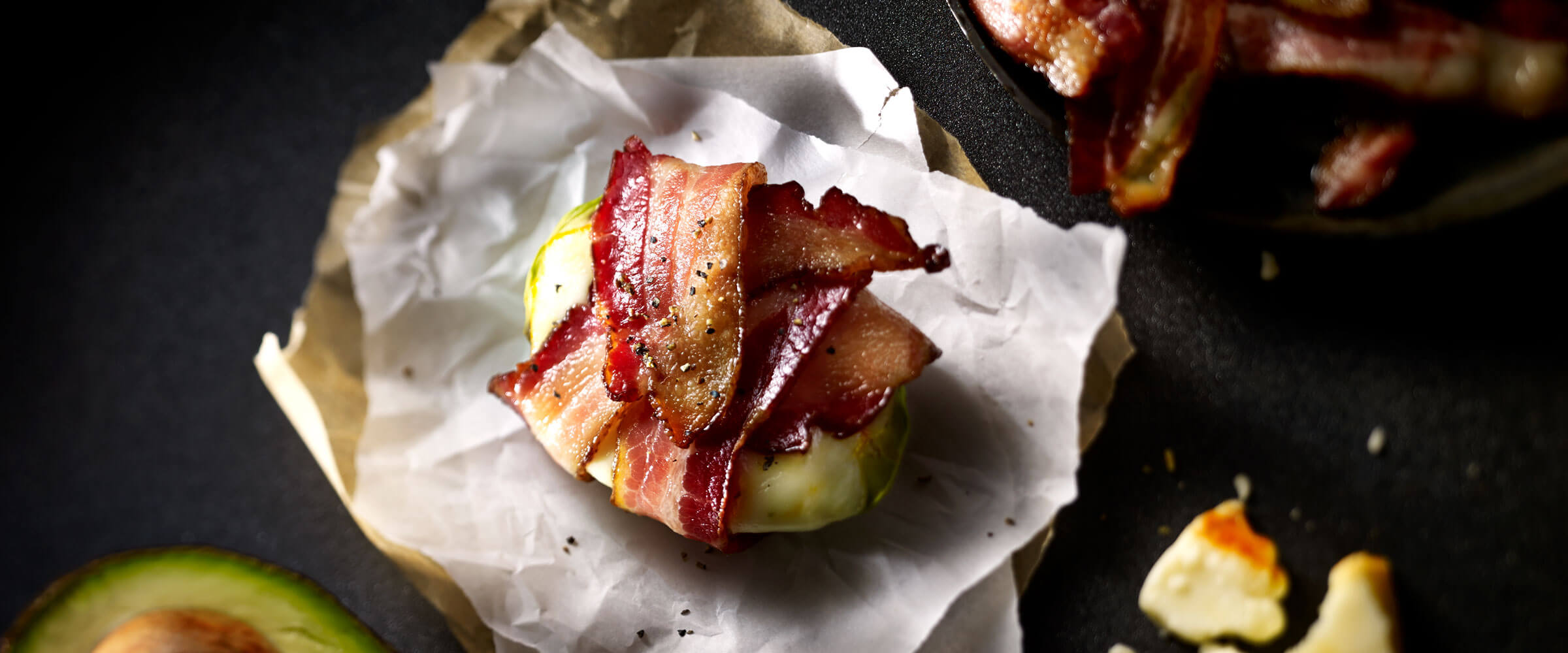 Bacon Wrapped Avocado on parchment paper