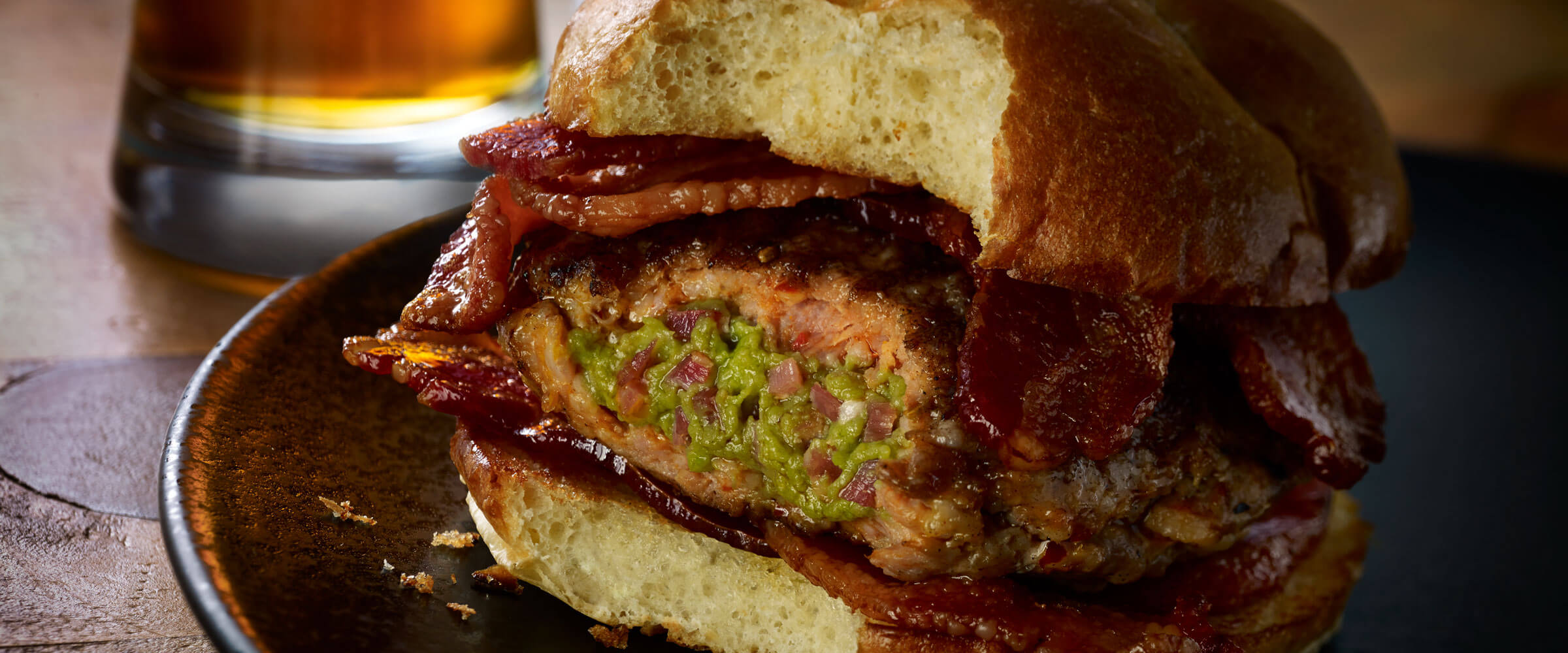 Bacon Guacamole Stuffed Sausage Burgers on brown plate