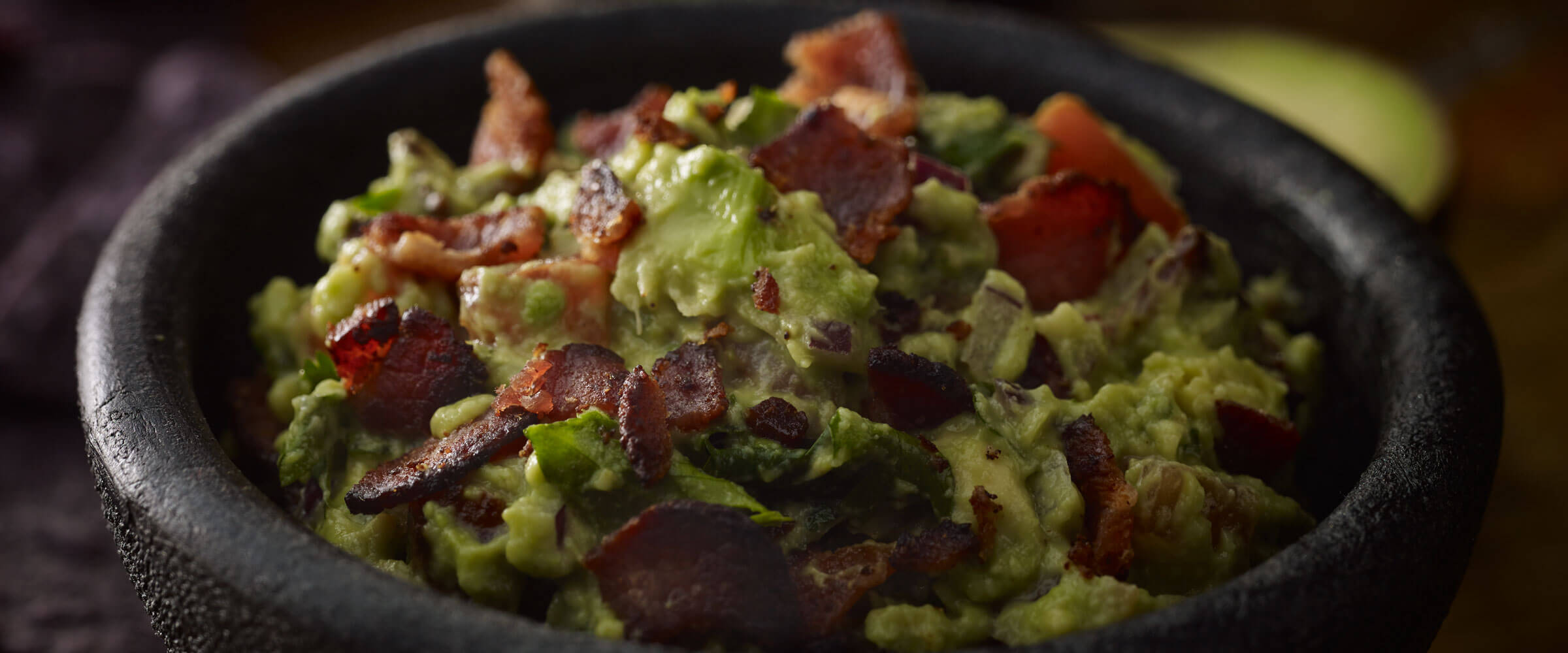 Spicy Bacon Guacamole in black bowl
