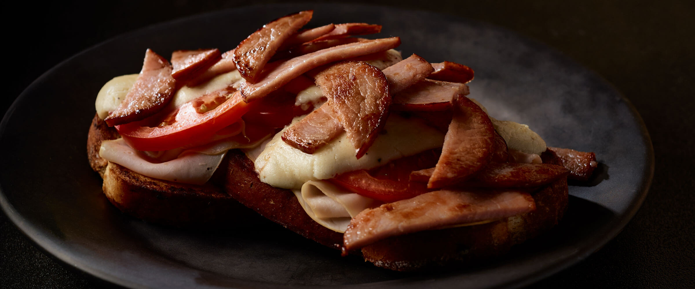 Canadian bacon Hot Browns on black plate