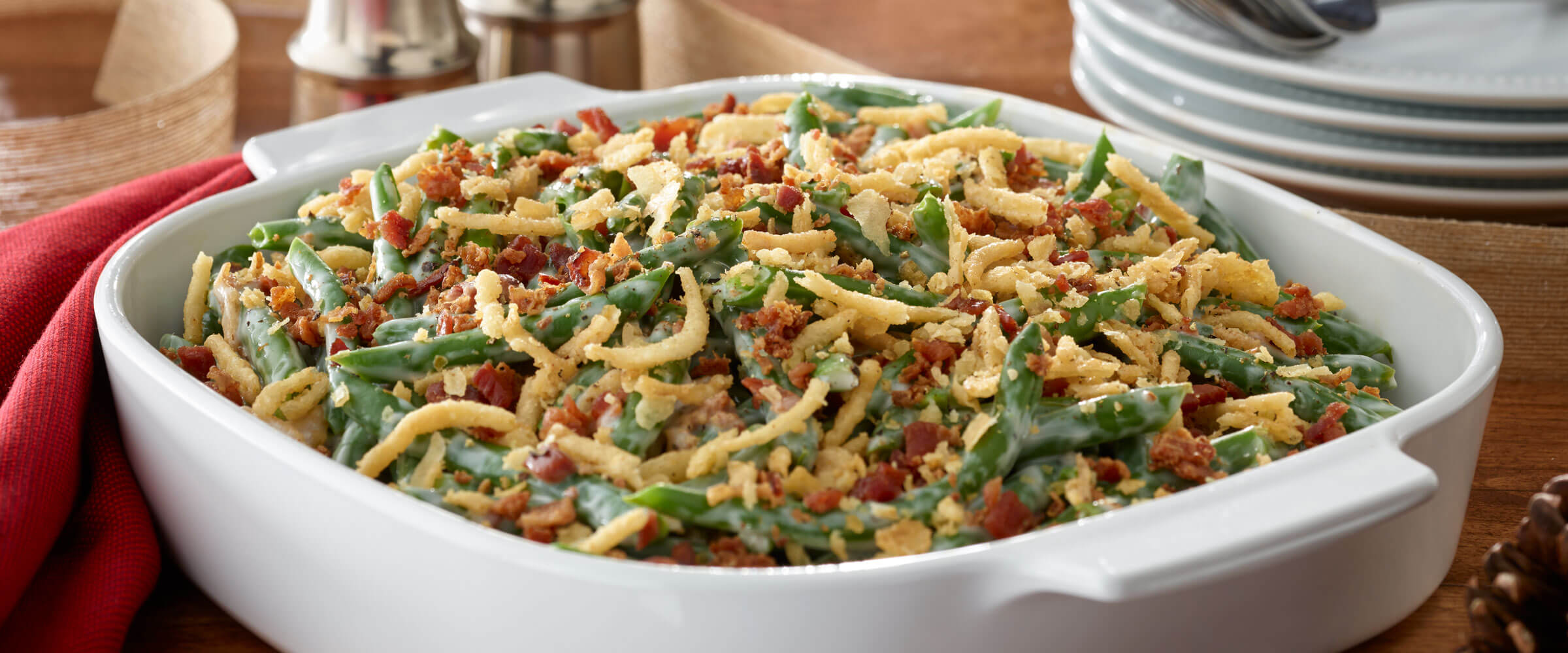 Bacon and Green Bean Casserole Deluxe in white dish with red napkin