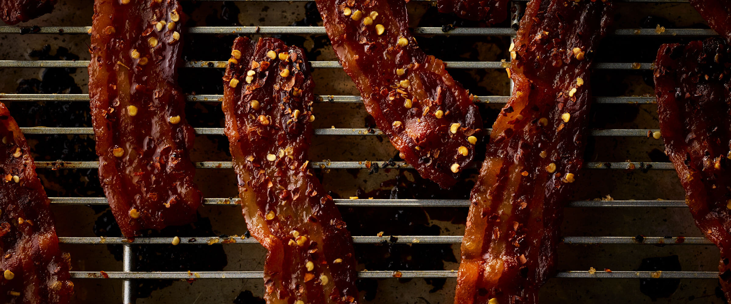Candied Bacon on wire rack with red pepper flakes