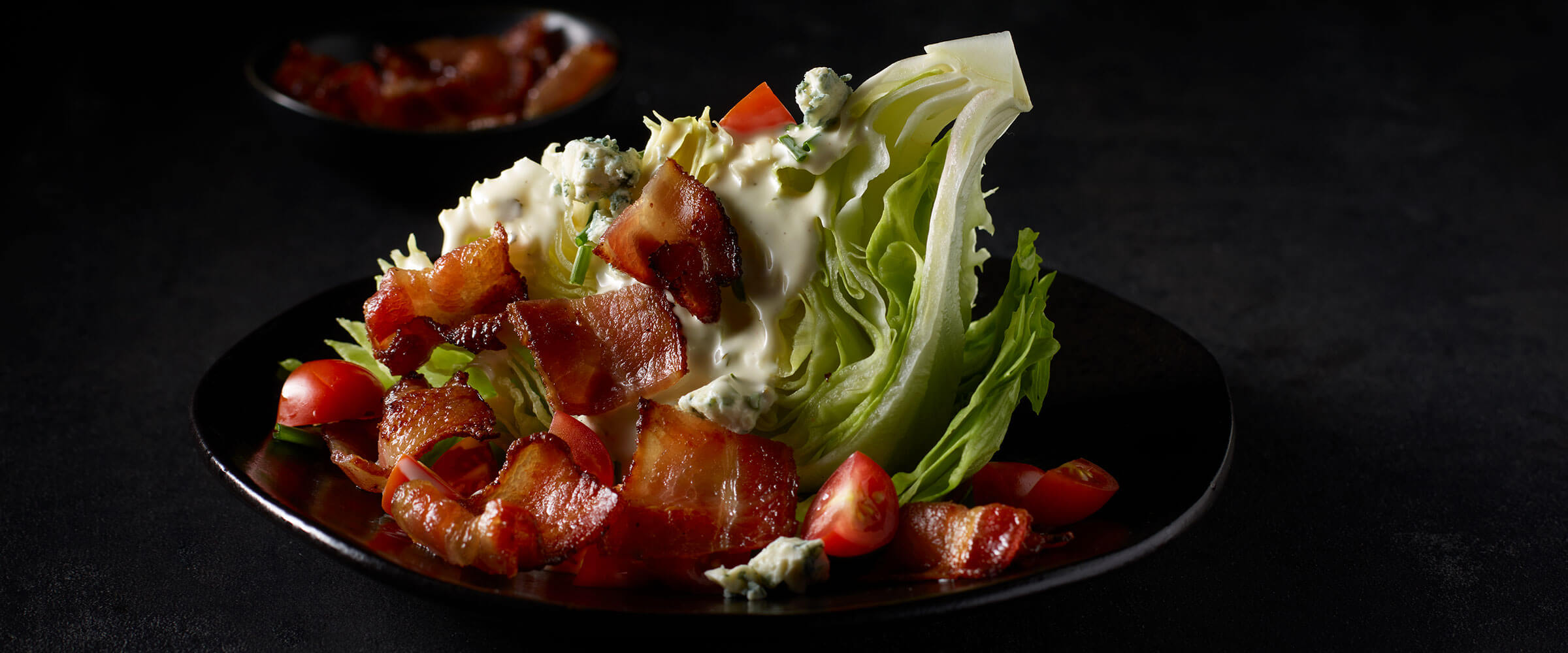 Bacon Wedge Salad on black plate