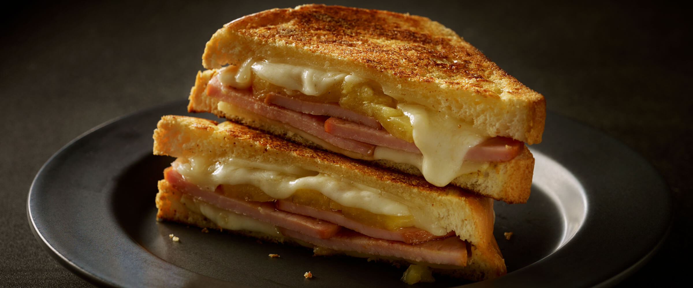 Hawaiian Grilled Cheese and Canadian Bacon Sandwich on black plate