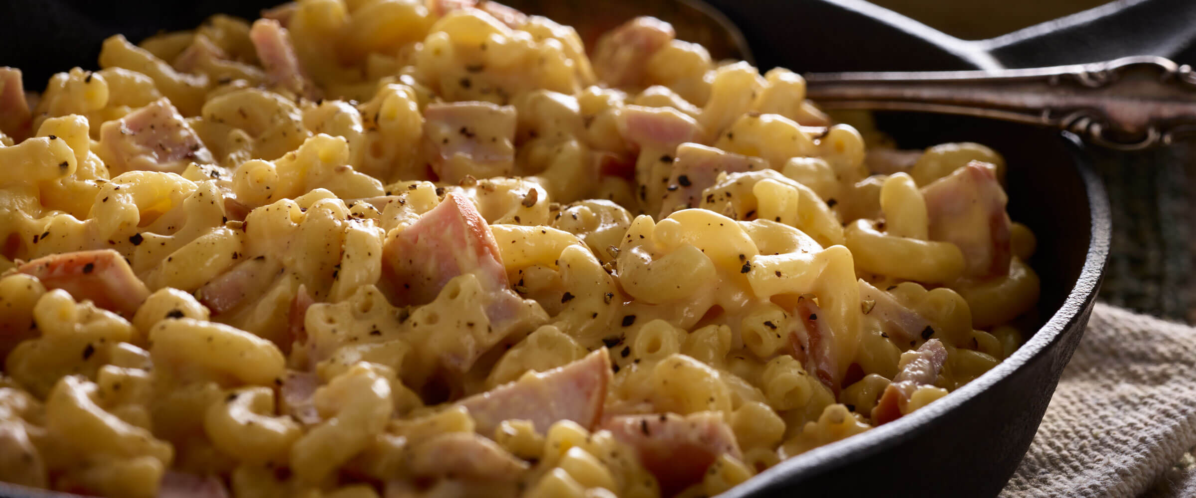 Skillet Canadian Bacon Macaroni and Cheese with serving spoon