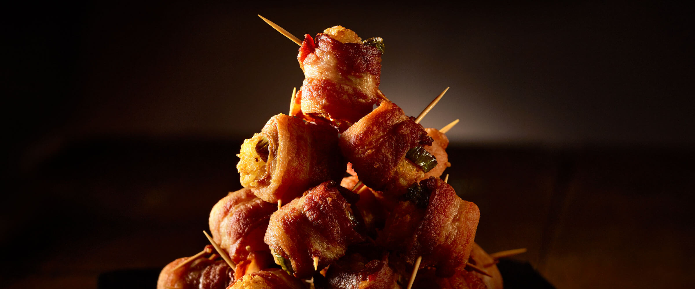 Jalapeno Bacon-Wrapped Tots with toothpicks stacked in pyramid