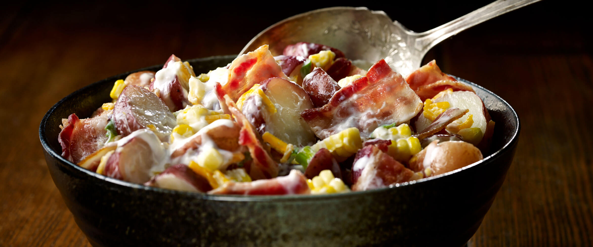 Bacon Potato Salad in bowl with serving spoon