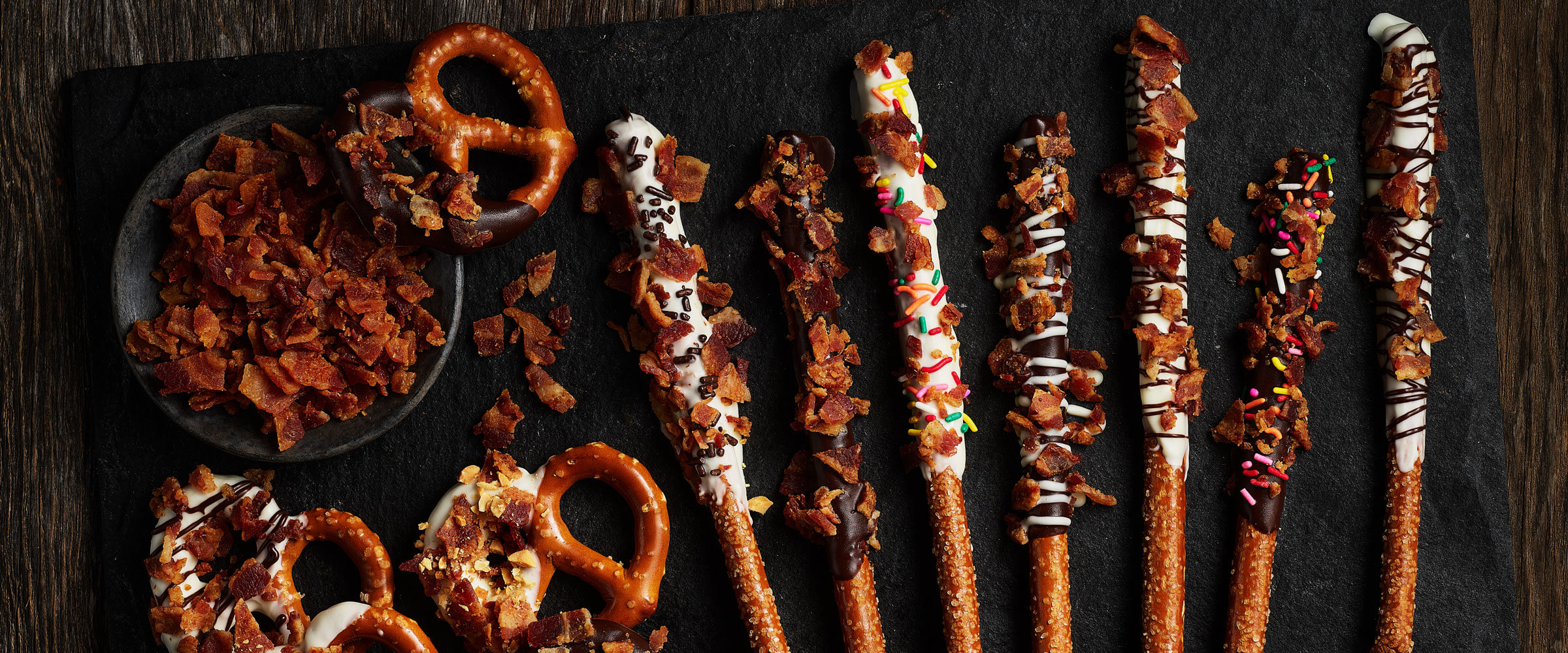 Dipped Pretzels with Bacon, frosting and chocolate on black board