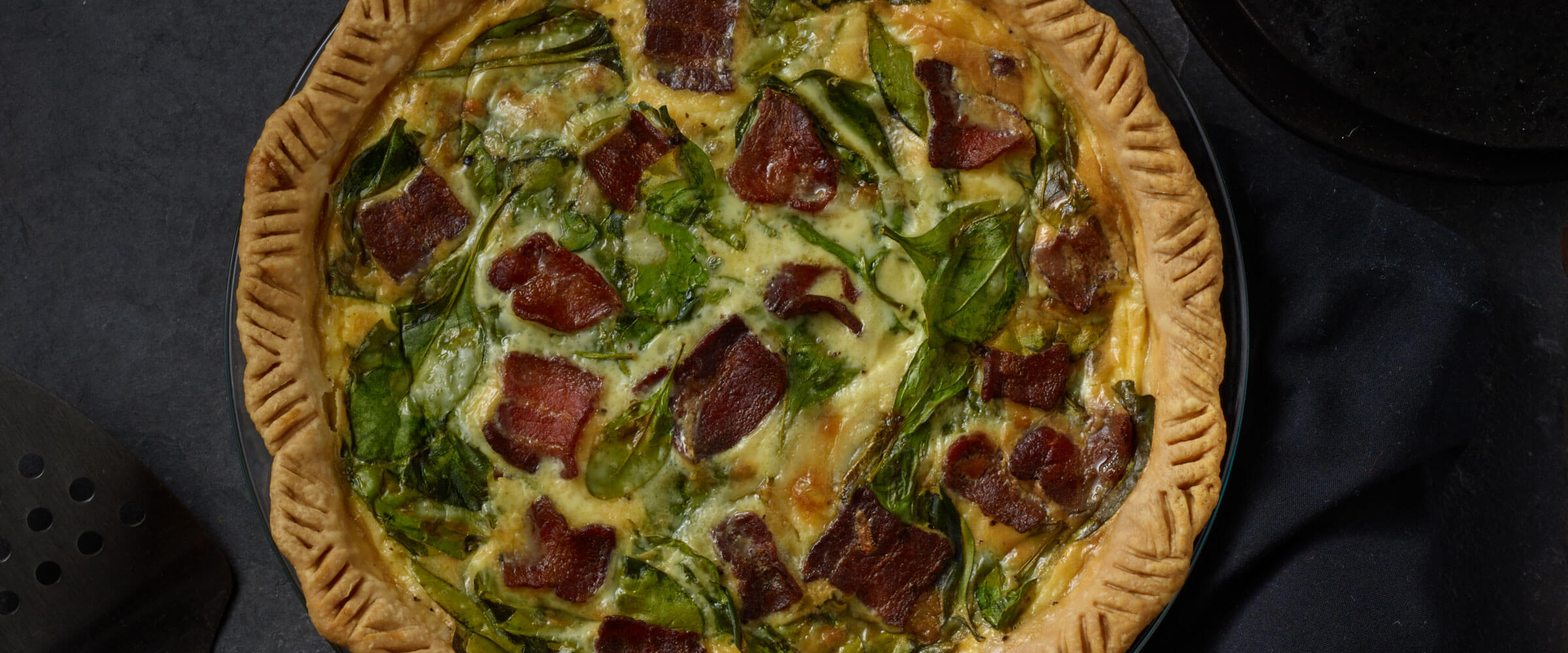 Bacon Spinach Quiche in black pan