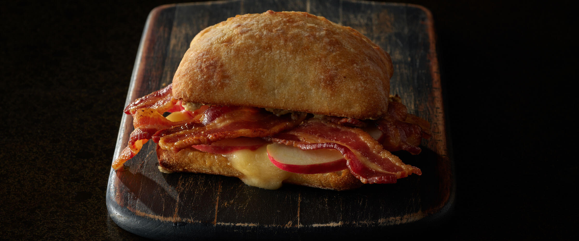 Apple Cider Bacon and Brie Sandwich on wood board