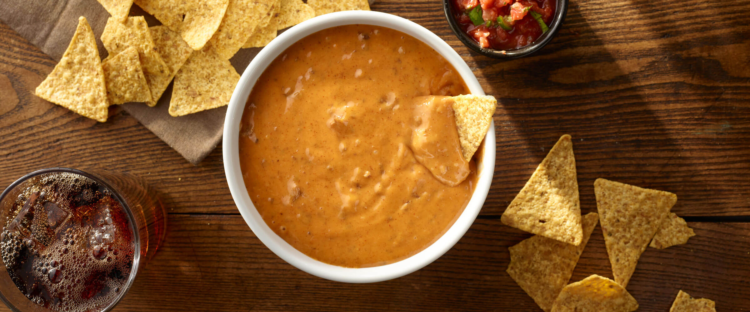 Chili Cheese Dip in white bowl with chips for dipping