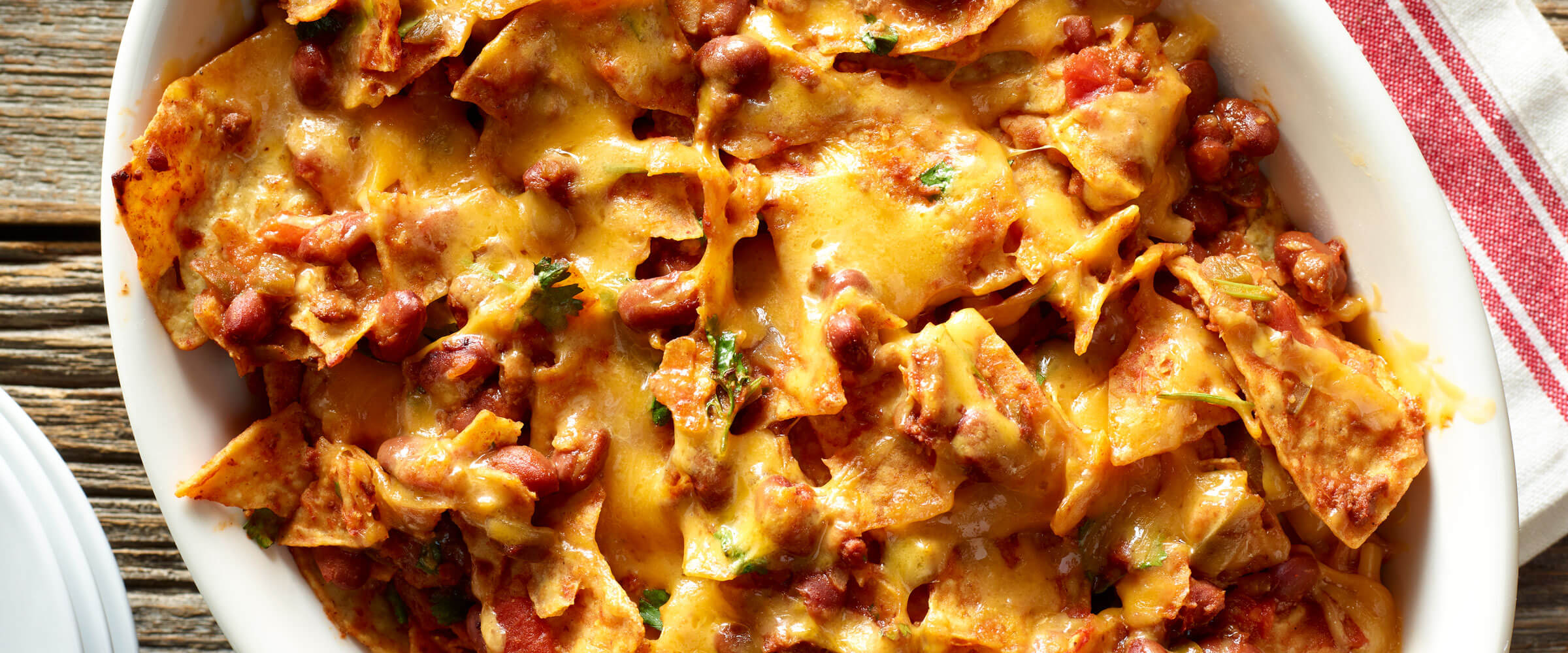 Chili Chips Casserole in white dish topped with cheese