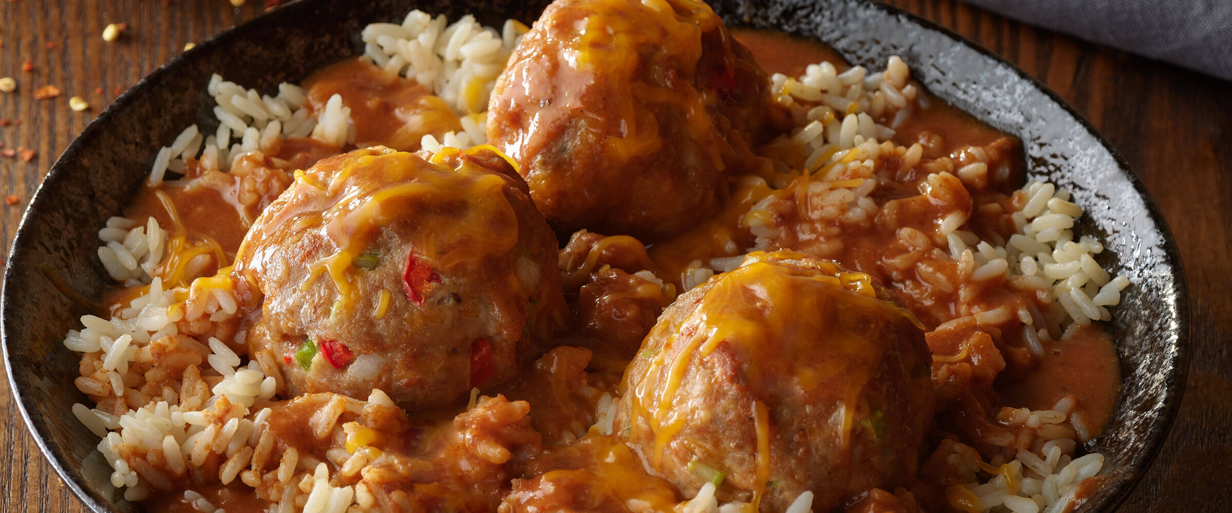 Turkey Meatballs with Tex Mex Gravy in black bowl over rice