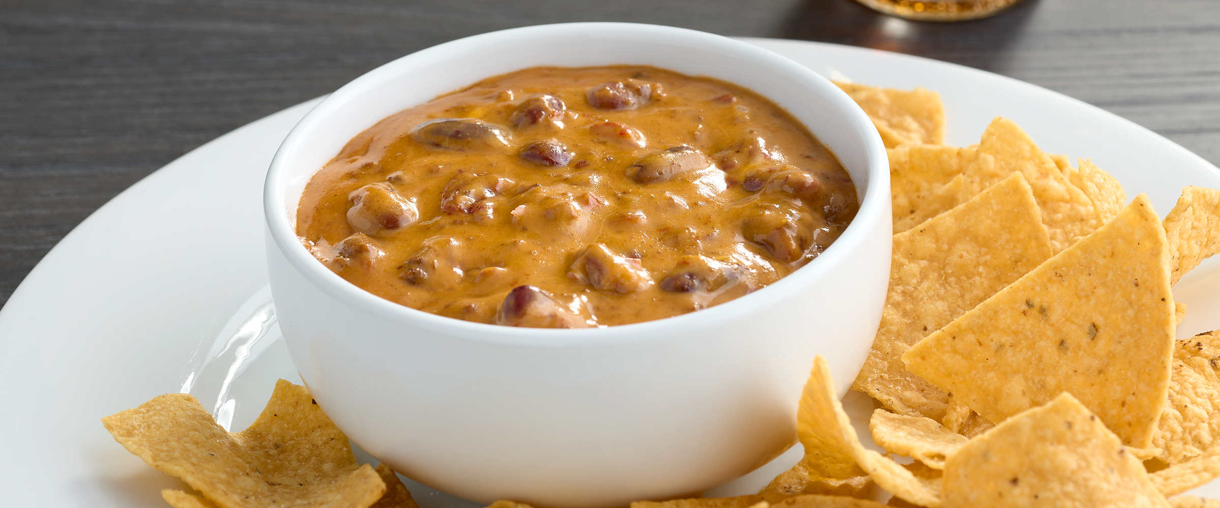 Microwave Chili Cheese Dip with tortillas on a white plate