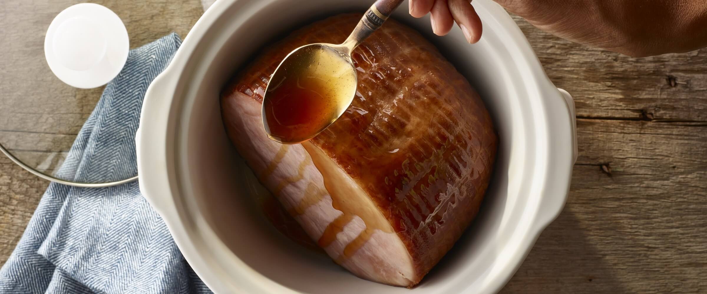Cure 81 slow cooker honey glazed ham with spoon drizzling with glaze