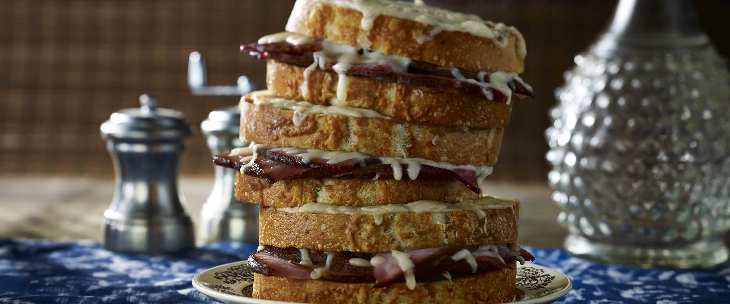 croque monsieur stacked three high with salt and pepper on side