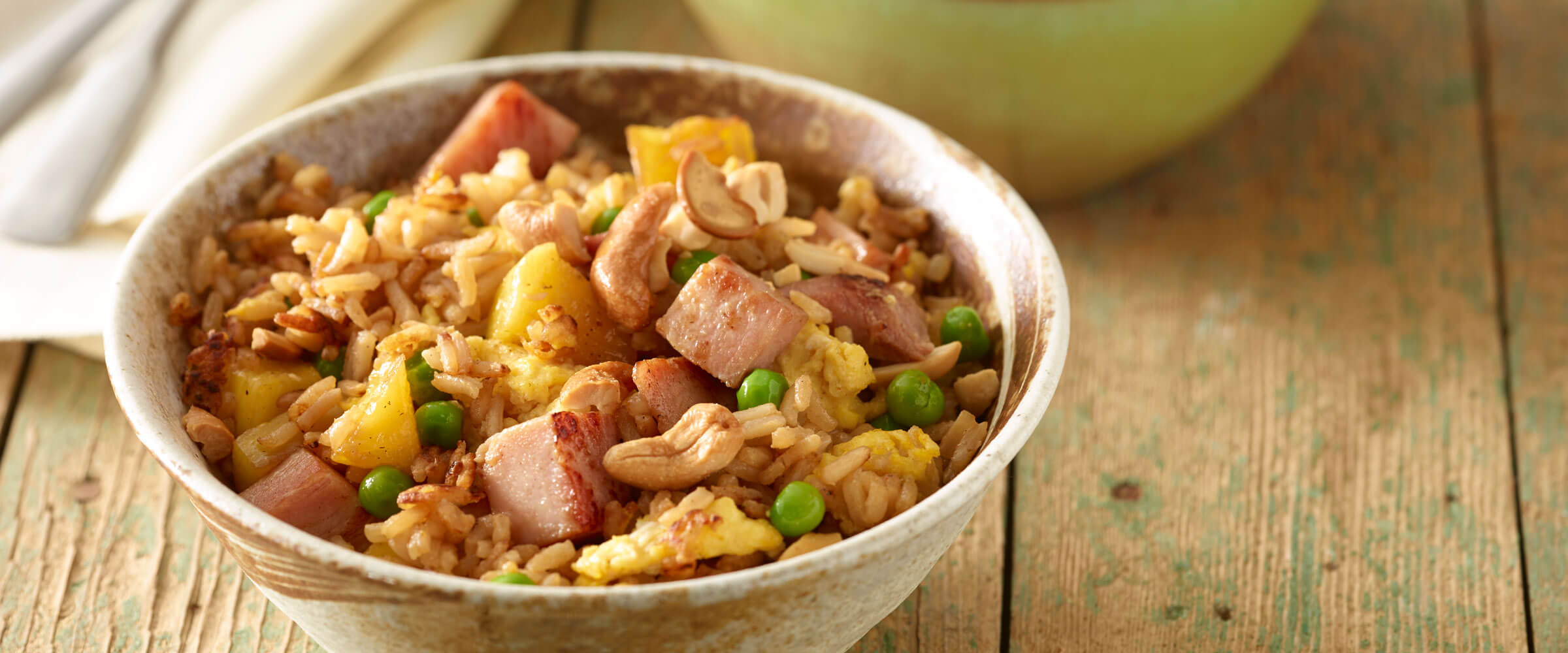 Ham and Pineapple Fried Rice in bowl on wood table