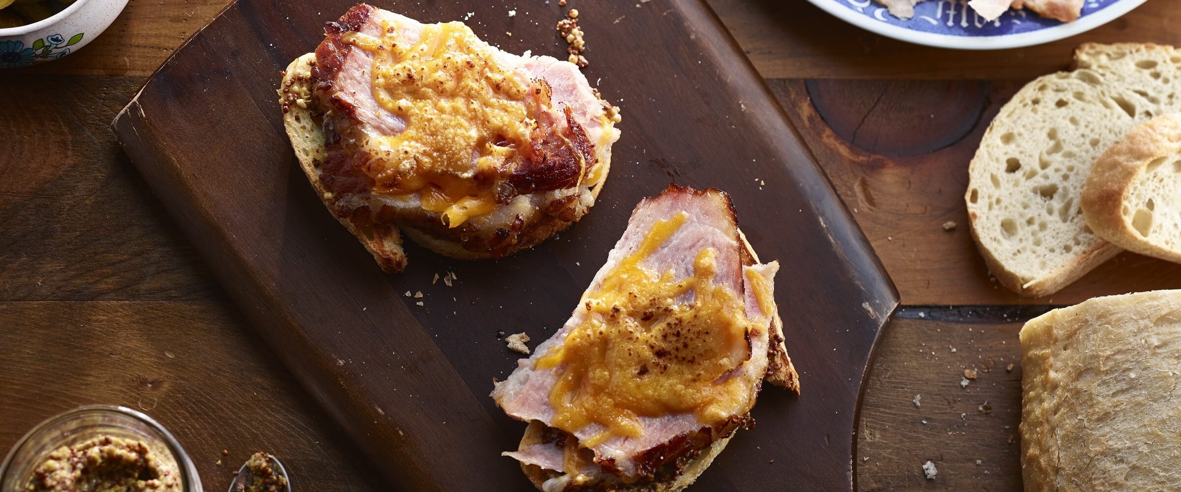 open faced grilled ham and cheese sandwich on wood board