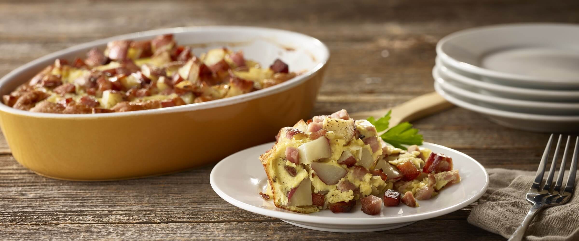ham potato breakfast bake in dish with serving plate