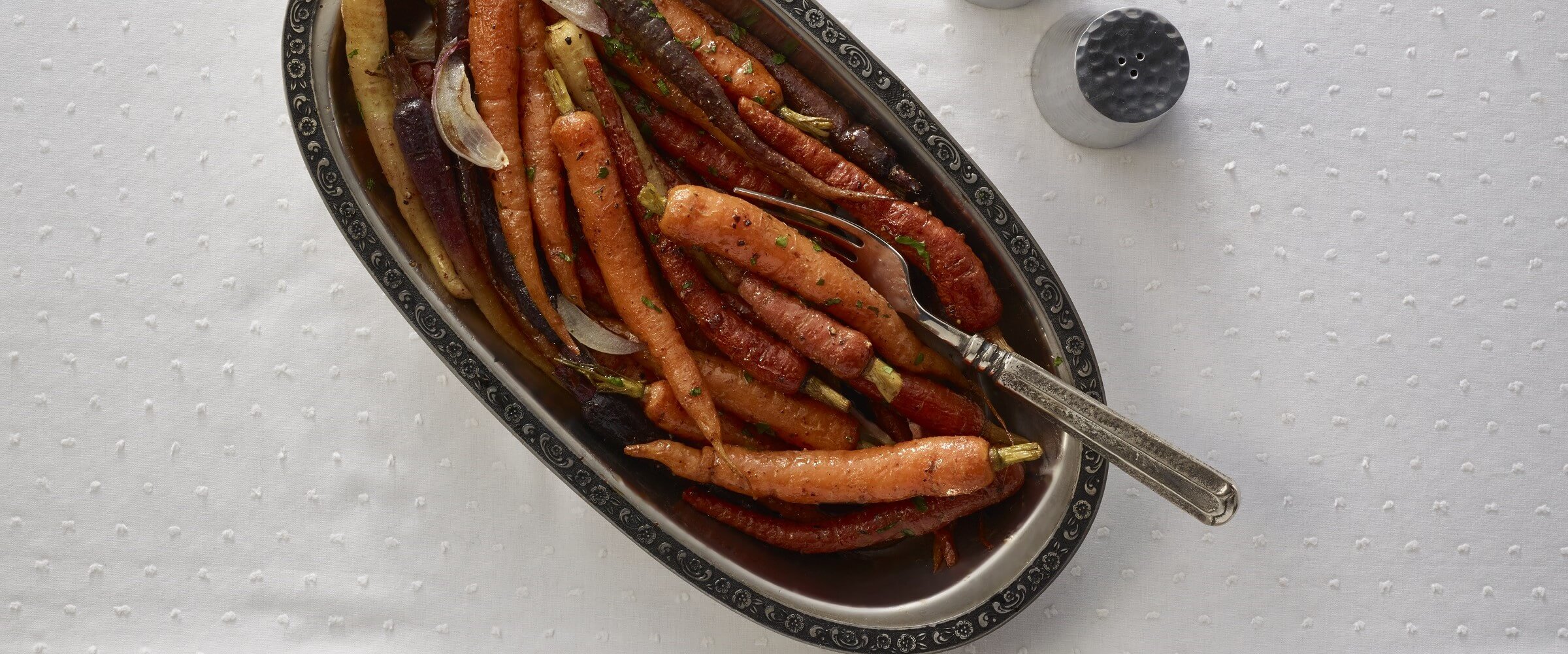maple dijon roasted carrots in dish with serving fork