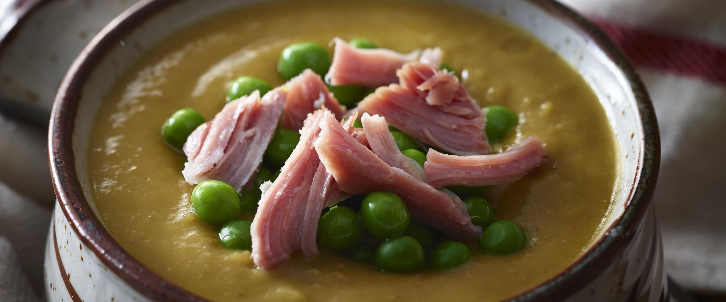 split pea ham soup topped with ham in pot