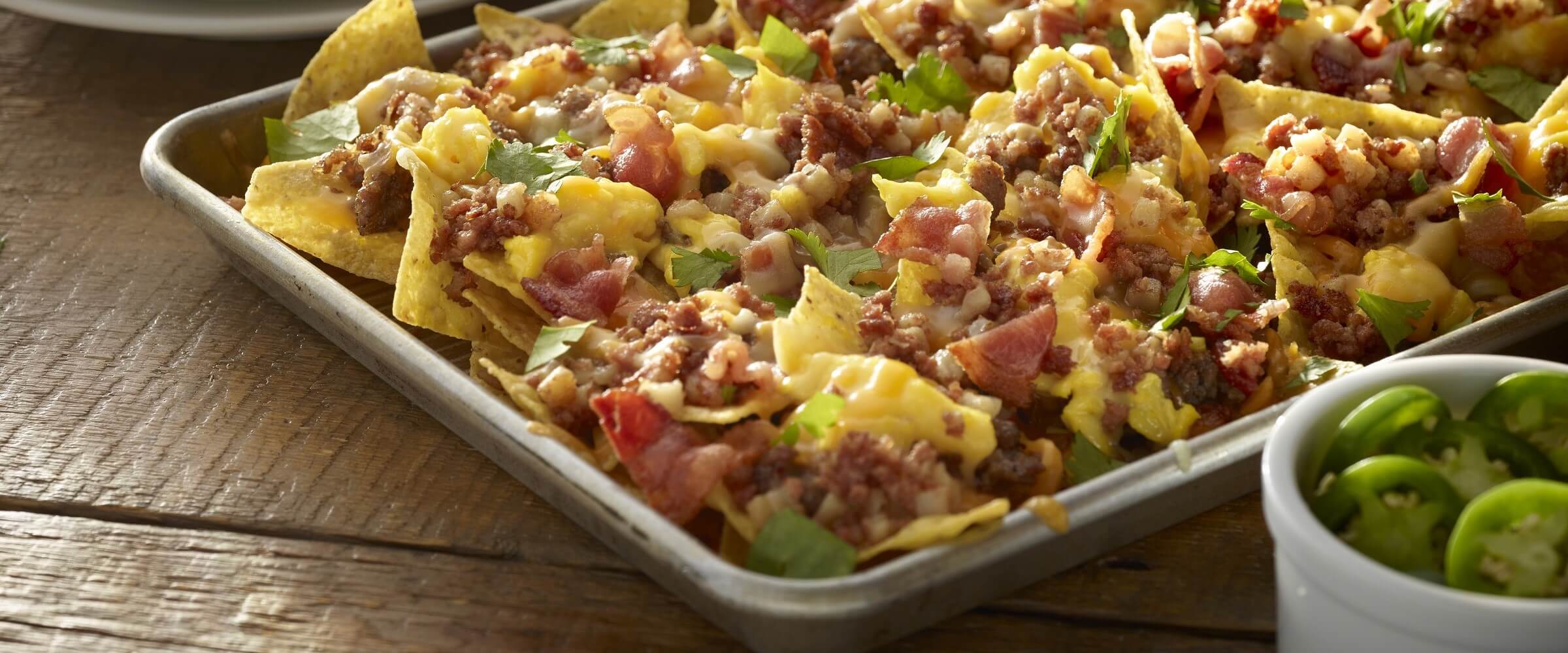 Corned beef hash ultimate nachos on sheet pan with jalapenos