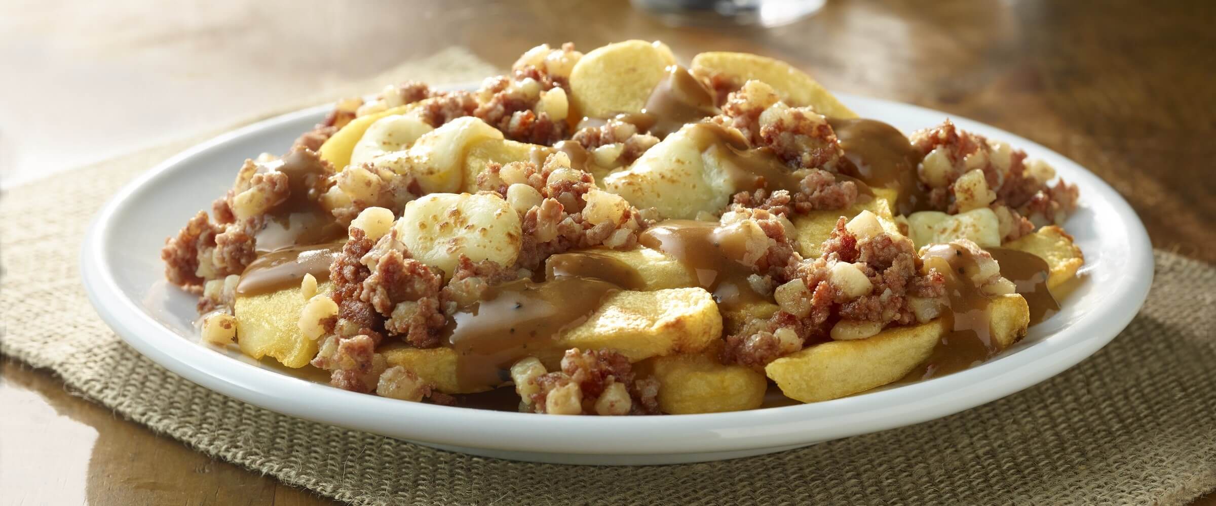 Corned beef hash poutine on white plate