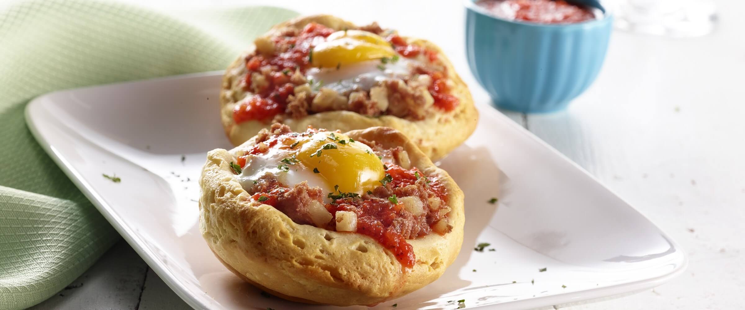 Corned beef hash breakfast cups on white plate with green napkin