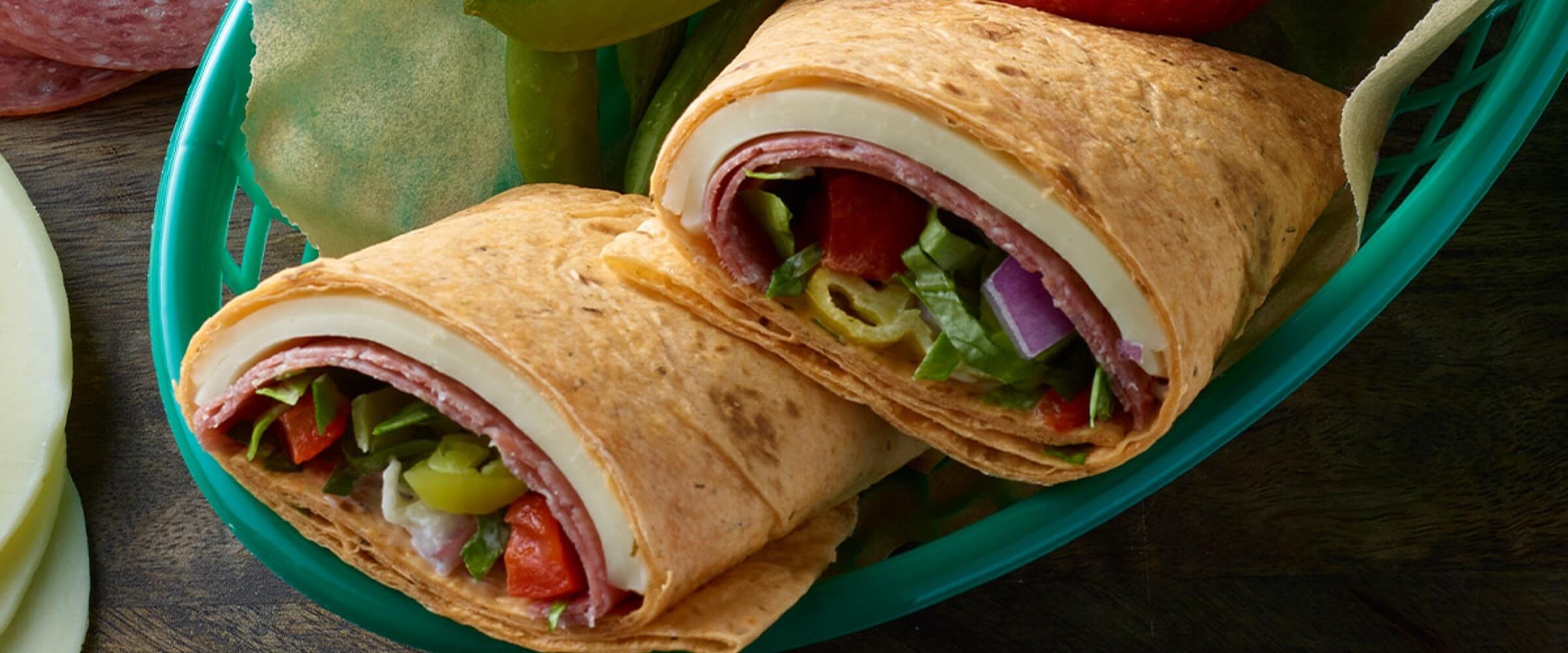 genoa wrap with cheese and vegetables in green basket