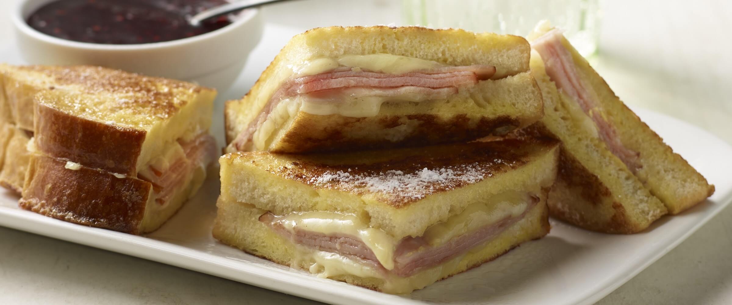 monte cristo sandwich on white plate with dipping sauce