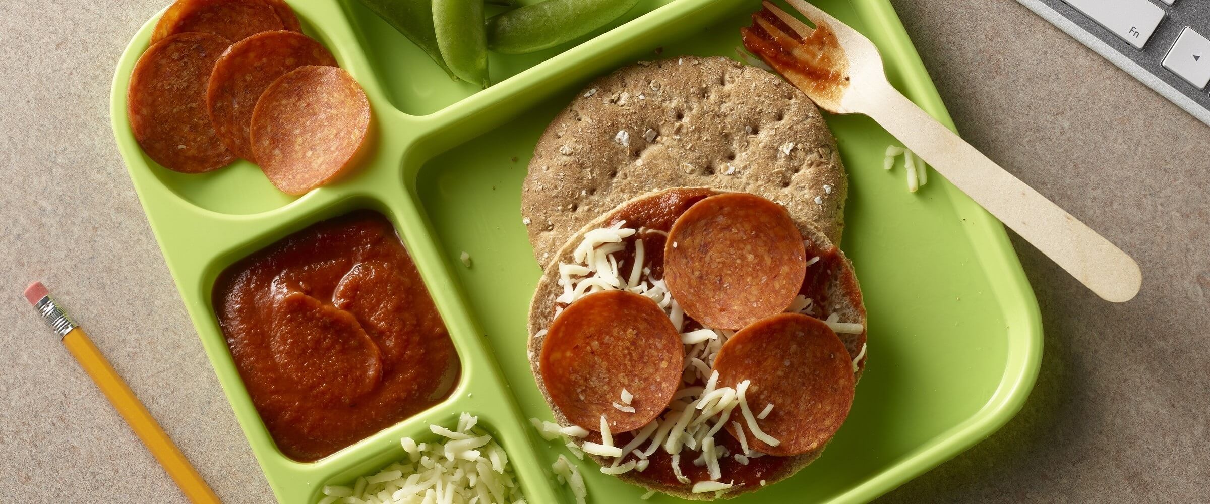 pepperoni pizza in green bento box with extra ingredients