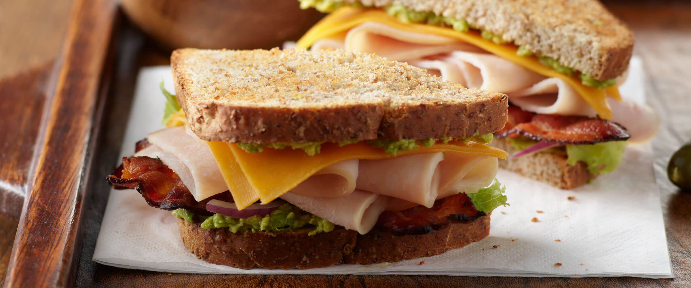 Club Sandwich on wheat bread on white napkin