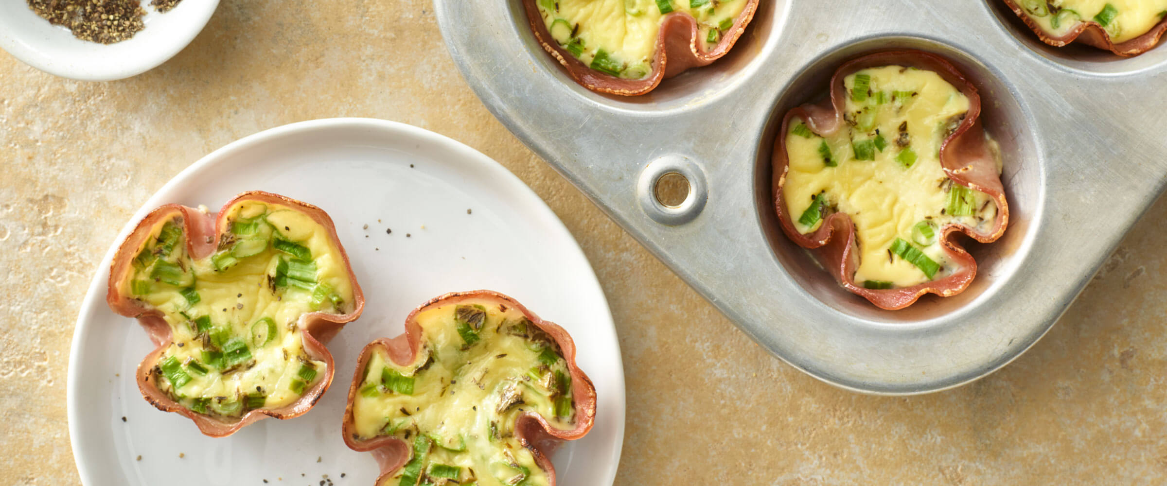 Ham and Quiche Cups in muffin tin and serving on a white plate