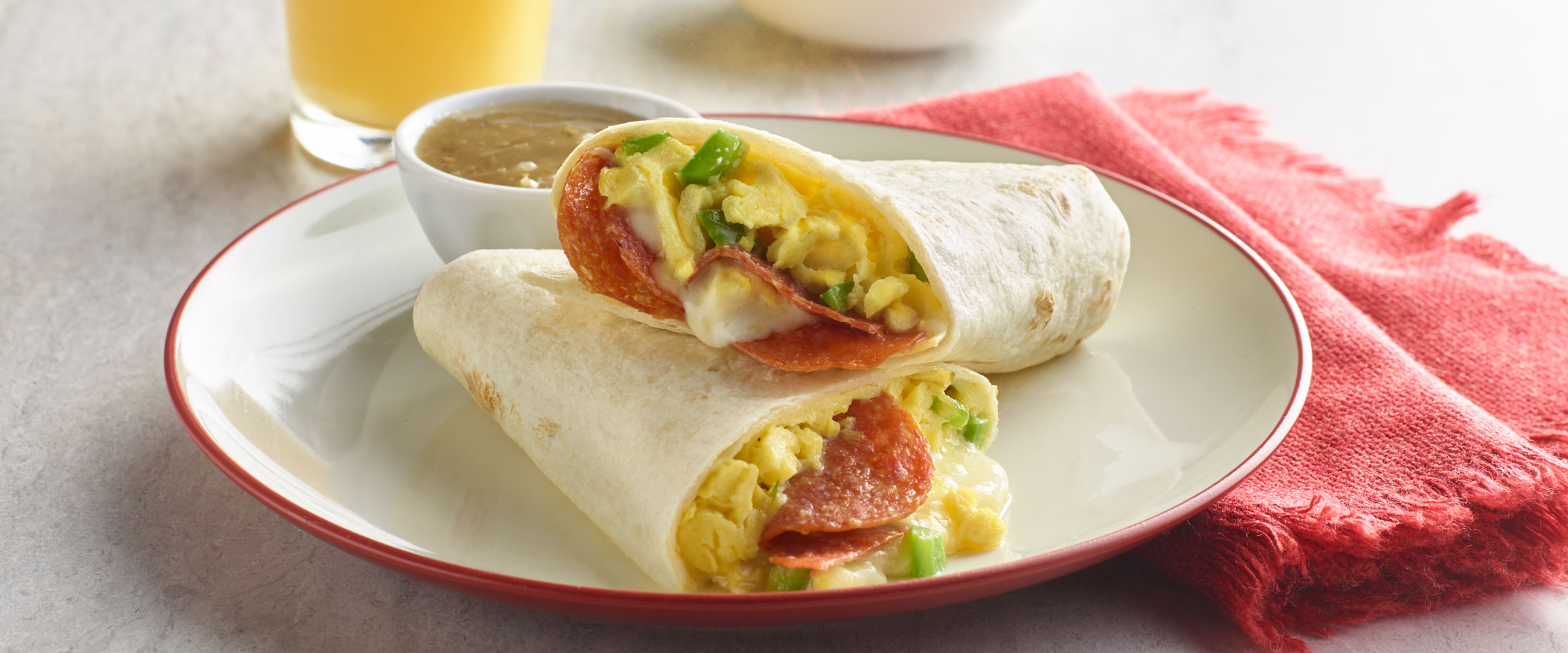 Italian Breakfast Burrito on plate with salsa and red napkin