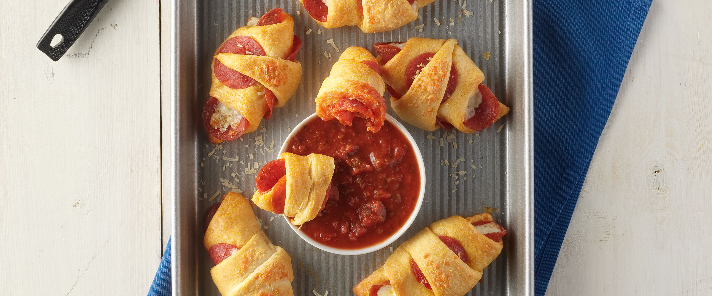 Cheesy Pep Roll Ups on sheet pan with dipping sauce