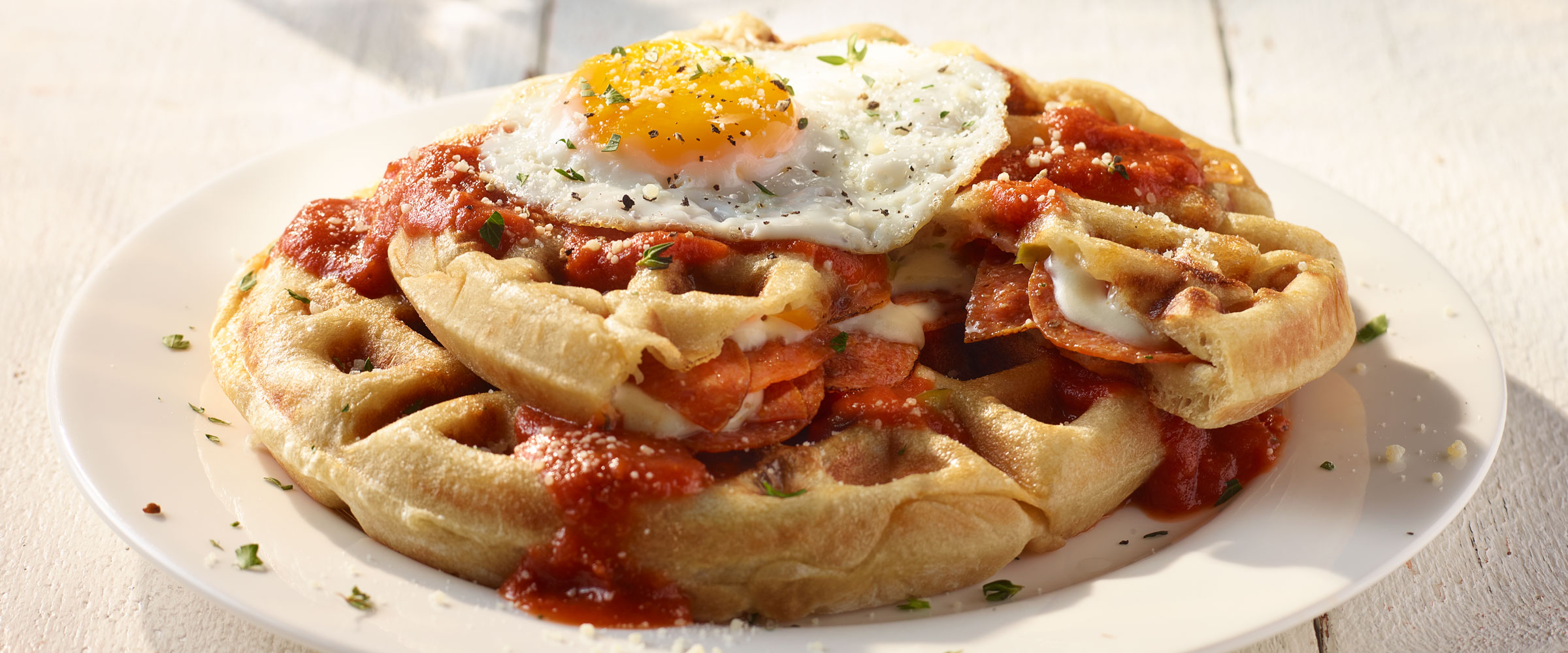 Savory Pepperoni Pizza Waffles with Egg on top on white plate
