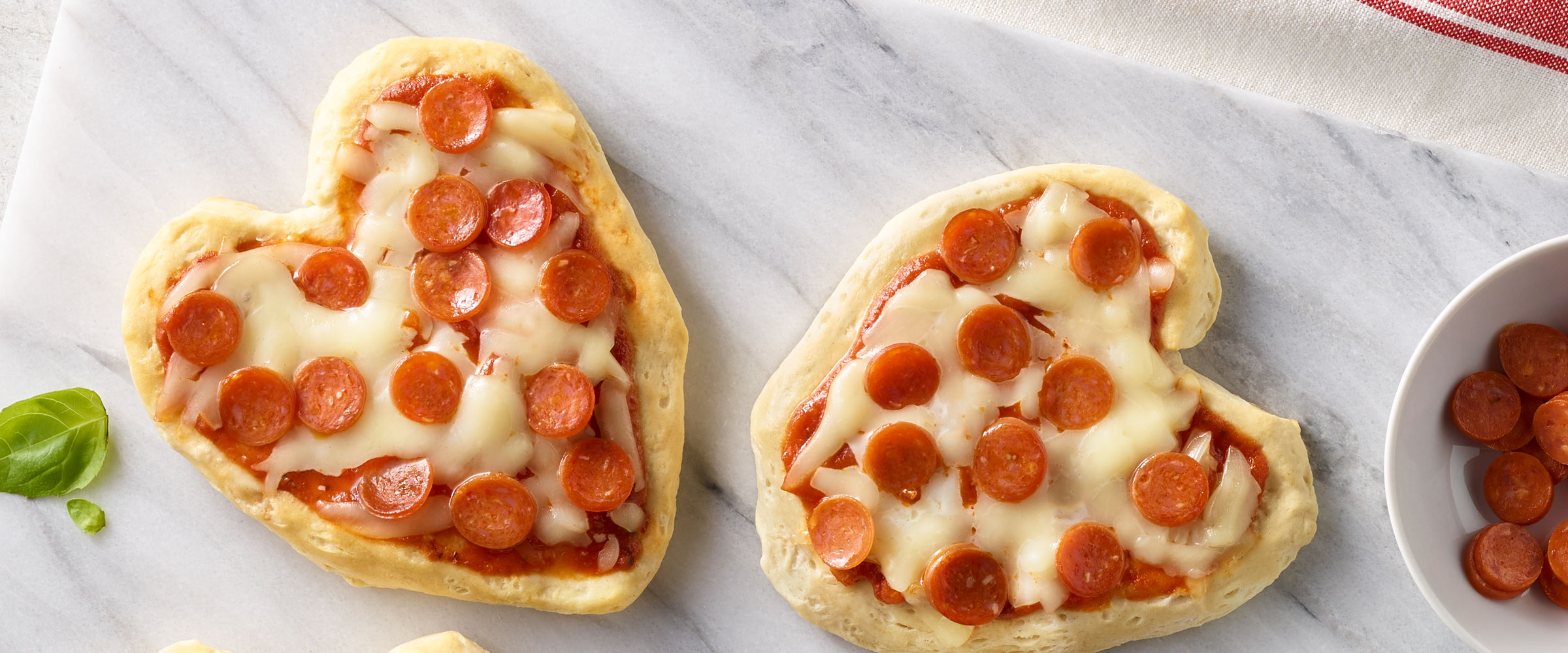 Pepperoni Heart-Shaped Mini Pizzas on white board
