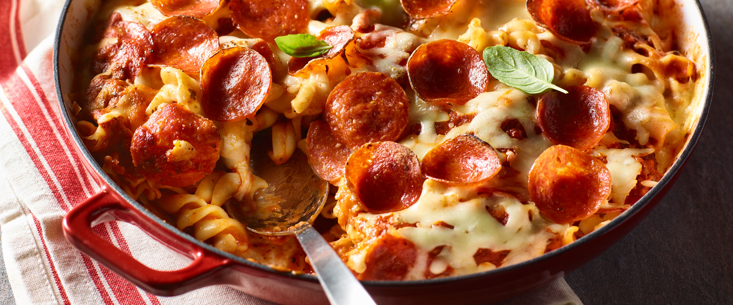 Pepperoni Pizza Pasta Bake in skillet on red and white linen