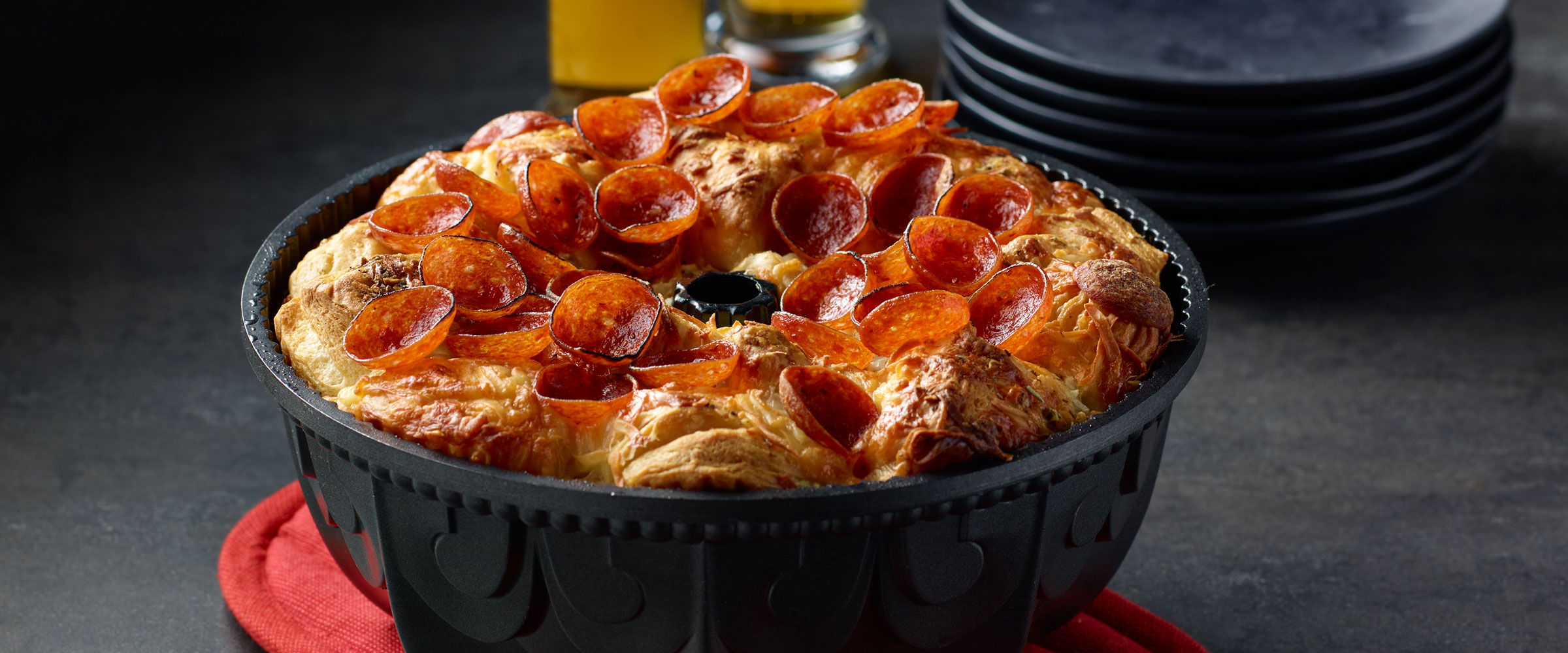 Cup N’ Crisp Pepperoni Pull Apart Bread in black dish on red pot holder