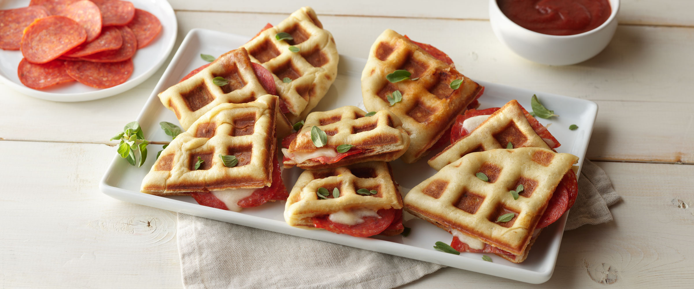 Pepperoni Pizza Waffles on white plate with dipping sauce