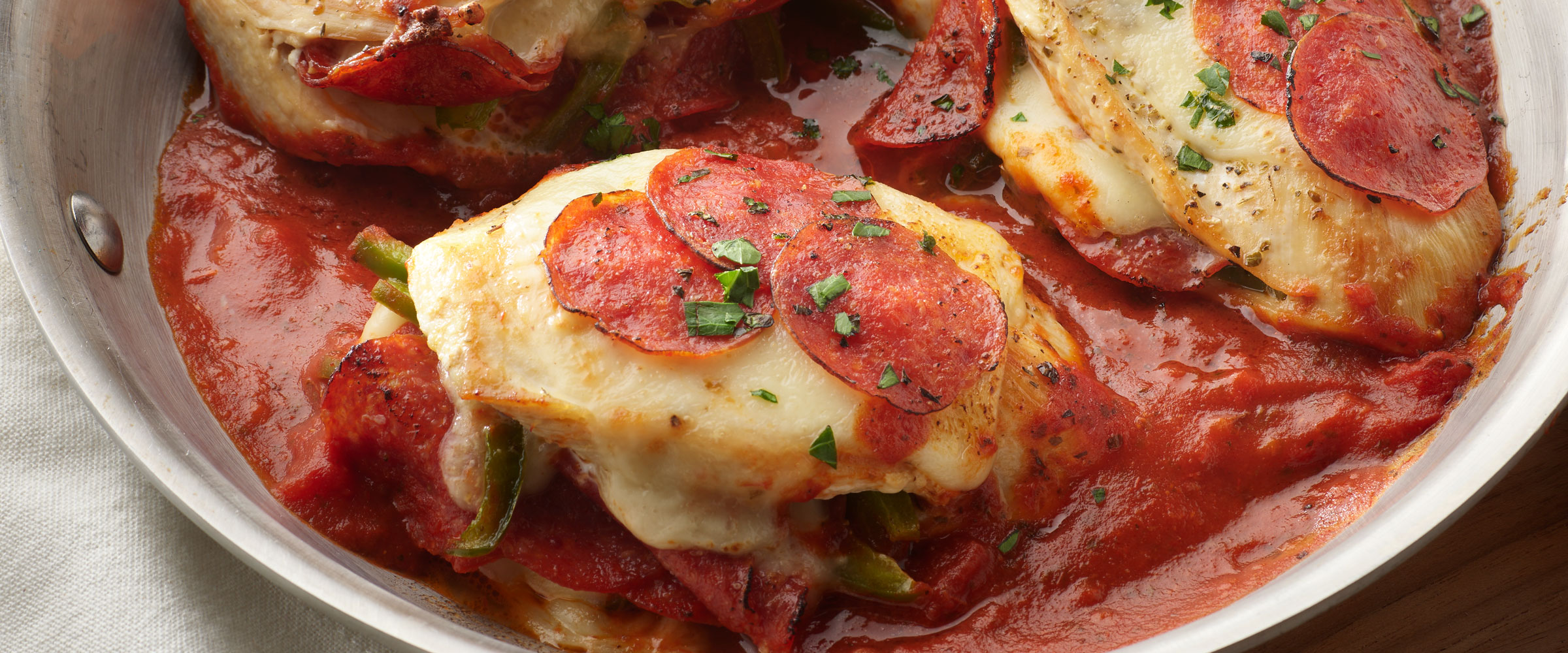 Pepperoni Stuffed Chicken with sauce in metal skillet