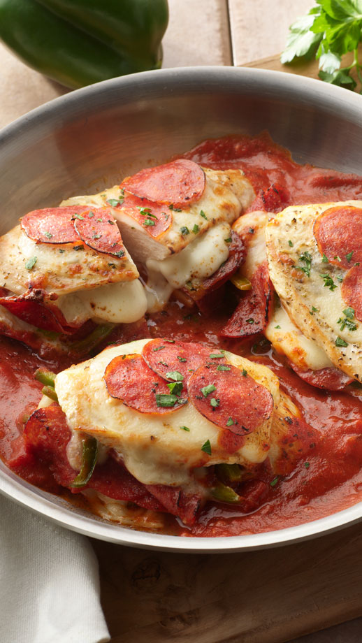 Close up of chicken in a tomato sauce with pepperoni on top