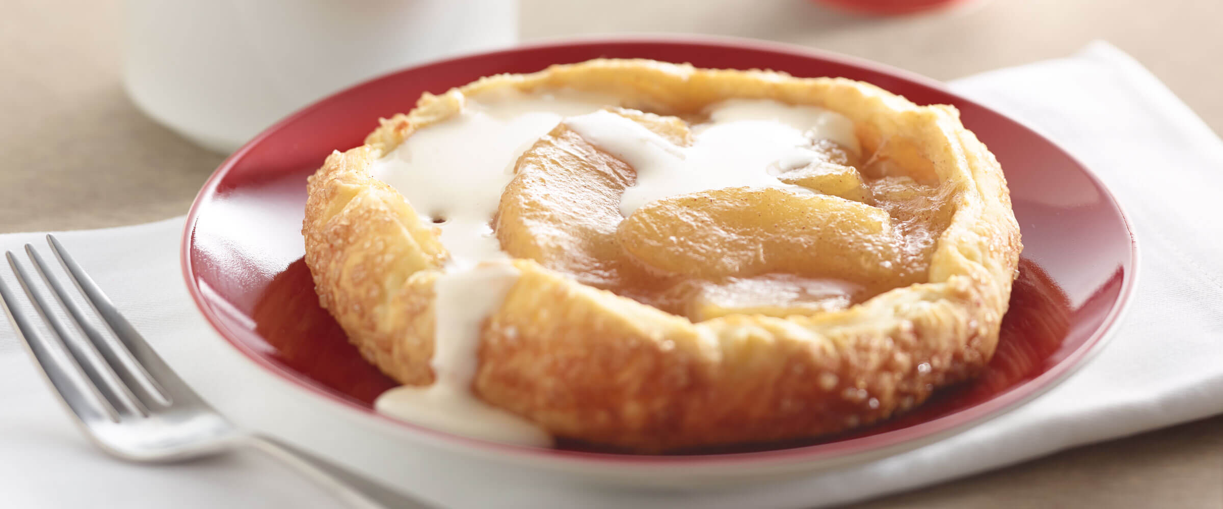 Apple pastries with frosting on red plate